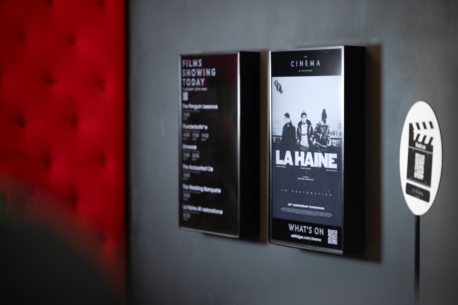 Digital screens displayed inside an indoor cinema space at Selfridges, lit with a softbox to balance the warm tungsten ambient bulbs and avoid reflections, commercial interior photography